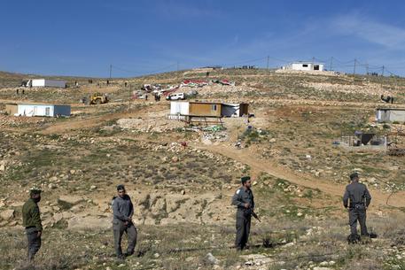 epa03581660 Israeli Border Police stand by as bulldozers demolish homes in the West Bank outpost settlement of Ma'ale Rehavam, south of Bethlehem and near the settlement of Tekoa, 13 February 2013. Half a dozen houses were destroyed after police removed personal belonging from the homes and made the settlers move to a nearby hill. One settler was arrested.  EPA/JIM HOLLANDER